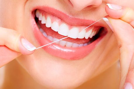 Clínica Dental Quintás limpiando dientes con seda dental
